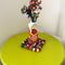 orange juice carton vase with flowers inside and on a green table